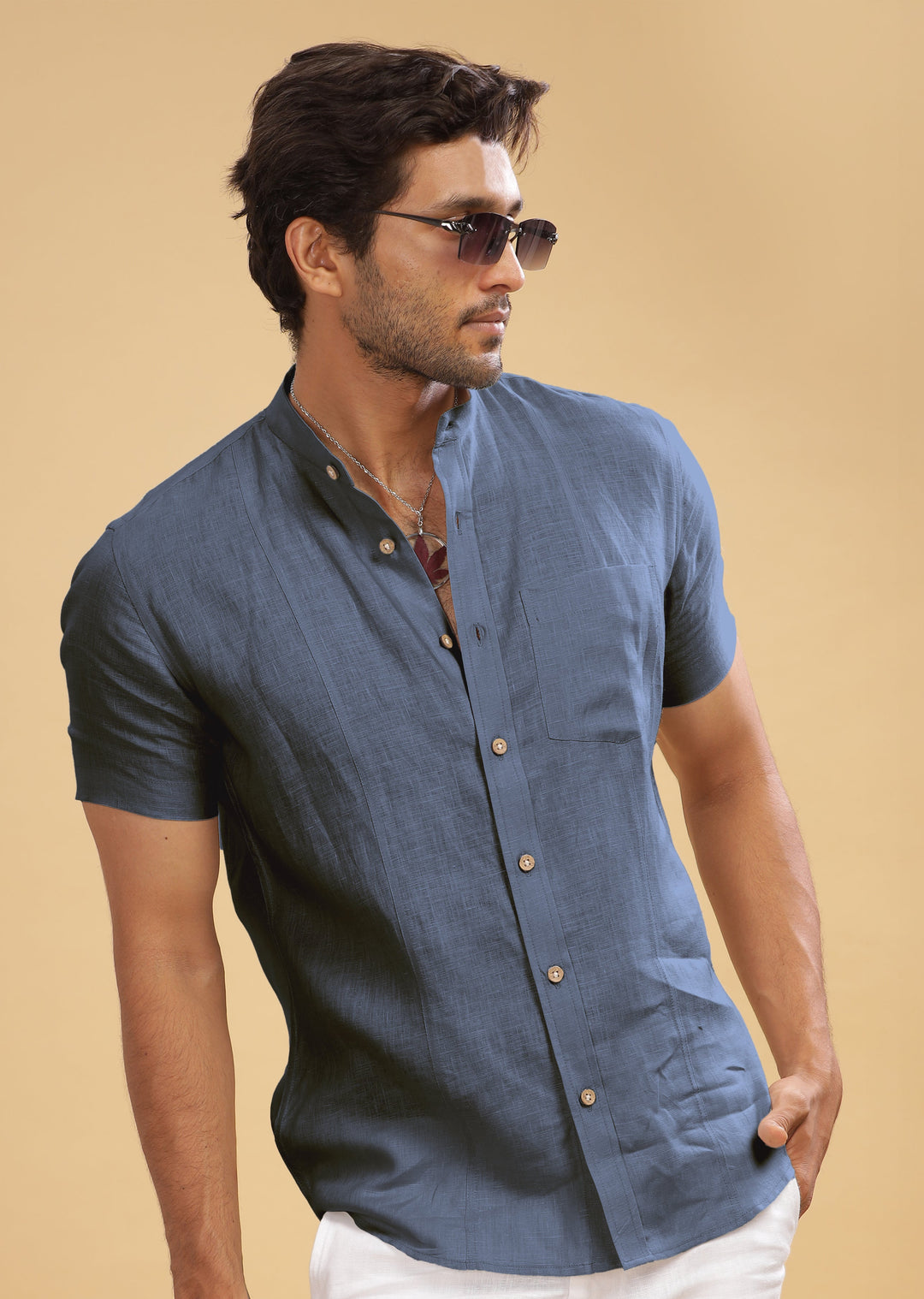 A man wearing a short sleeve pure linen shirt with a mandarin collar, in gunmetal grey color.