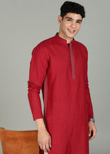 Man wearing a 100% pure linen mud red long kurta in 60 LEA with white detailing against a gray background