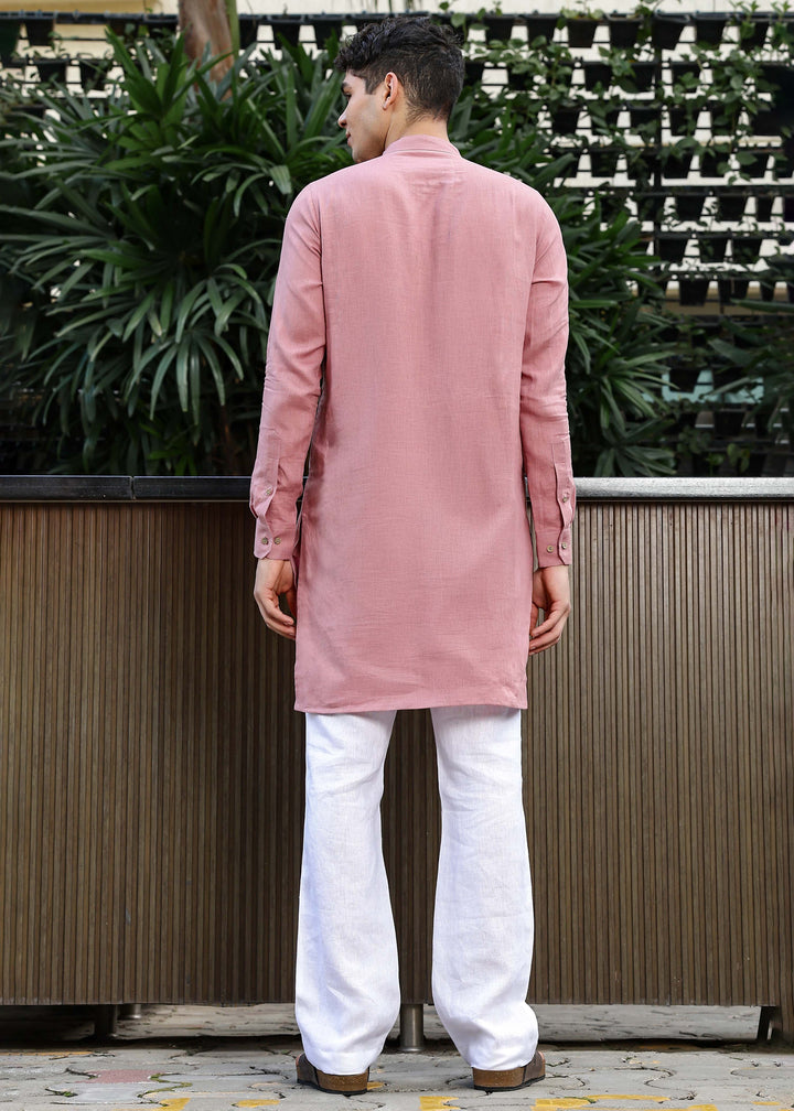 Man wearing a 100% Dusty pink yellow Kurta, in a Green outdoor Background.
