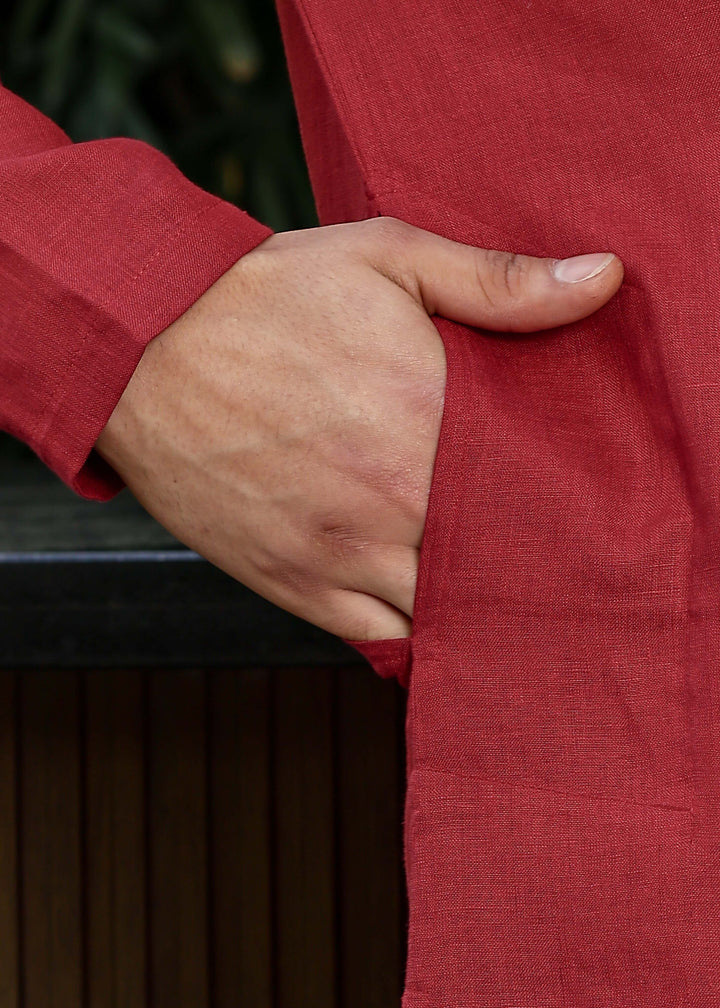 Man wearing mud red Kurta, 100% pure linen, outdoor green background.