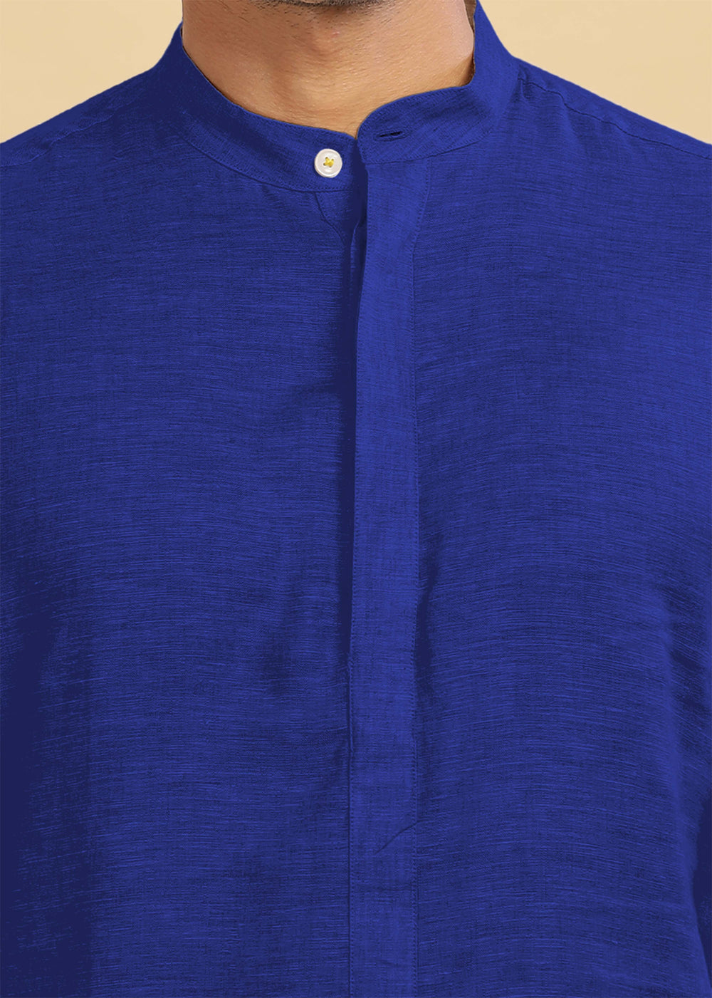 Close-up of a 100% pure linen egyptian blue kurta with a button on a beige background