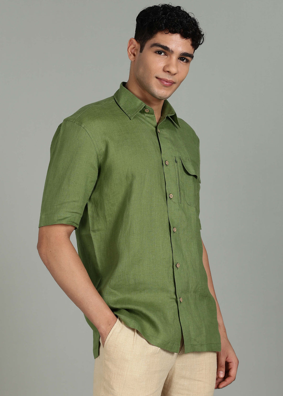 Man wearing 100% 60 LEA Cossack Green Half sleeve Shirt in an indoor grey background.