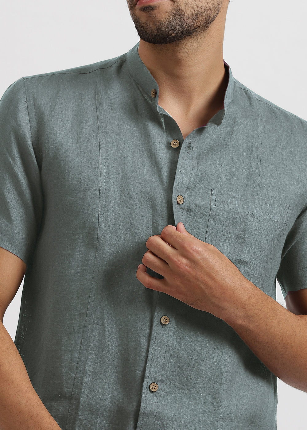 Man wearing a 100% pure linen mineral grey shirt with button details on a plain background