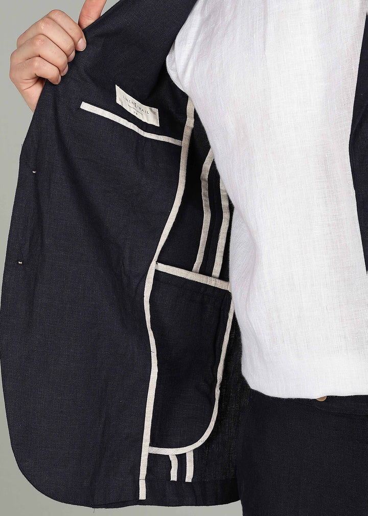 Man wearing a 100% pure linen regal blue jacket in 25 LEA over a white shirt on a gray background
