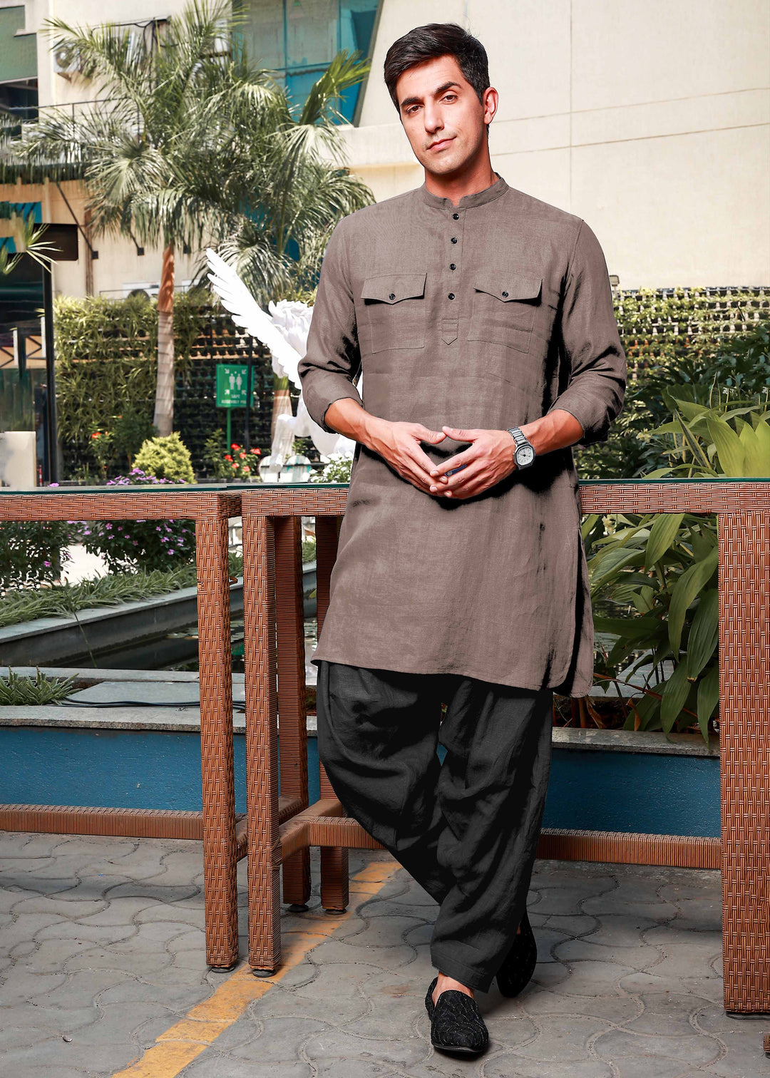Man wearing a 100% pure linen fawn pink long kurta with black pants standing outdoors.