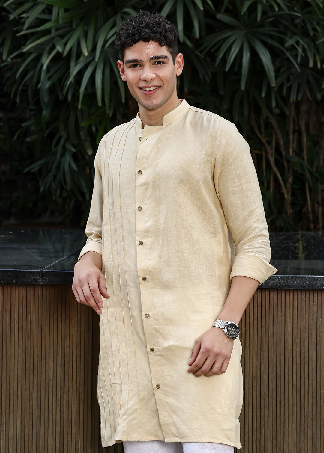 Man wearing a 100% pure light tea yellow Kurta, in a Green outdoor Background.