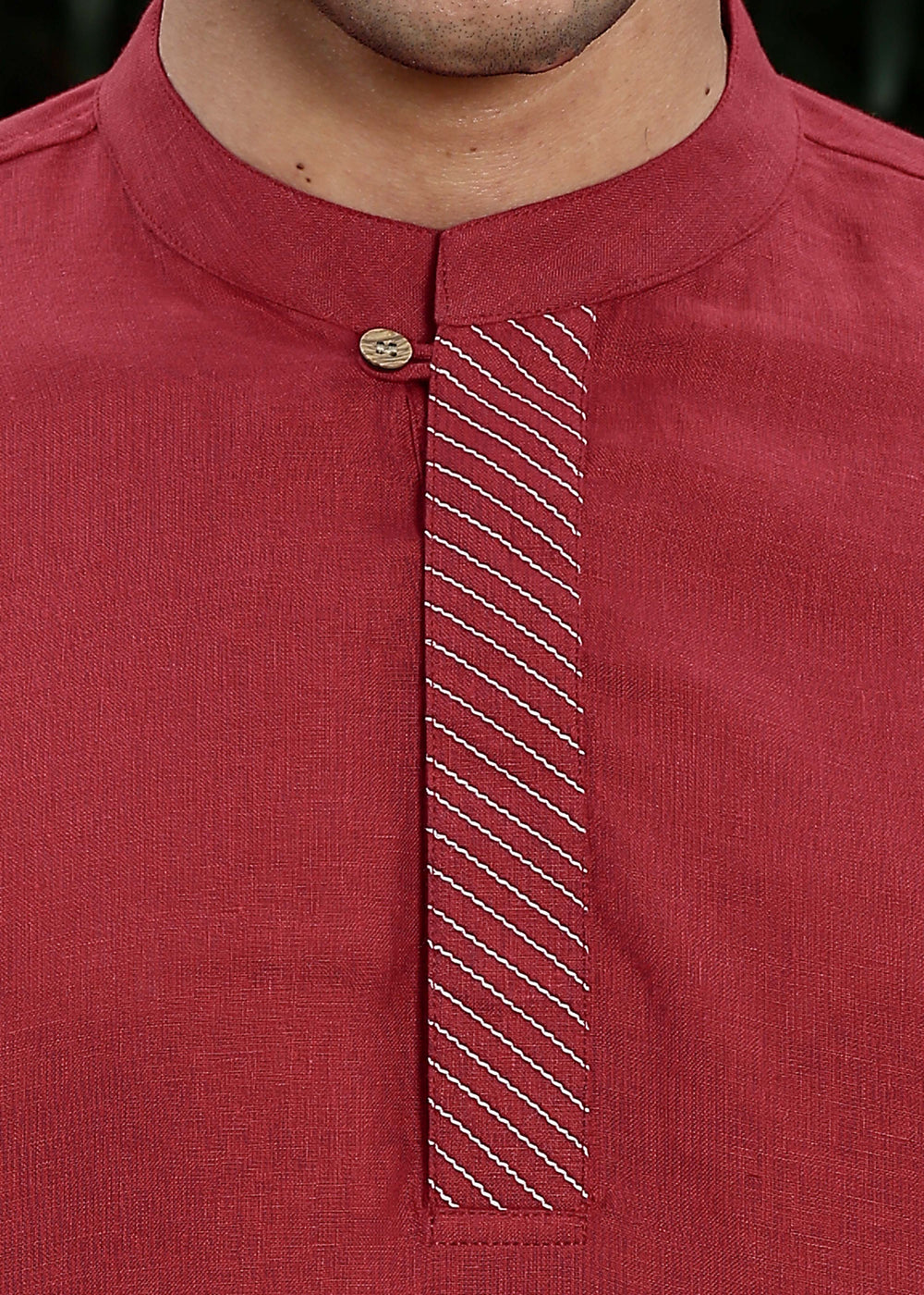 Man wearing mud red Kurta, 100% pure linen, outdoor green background.