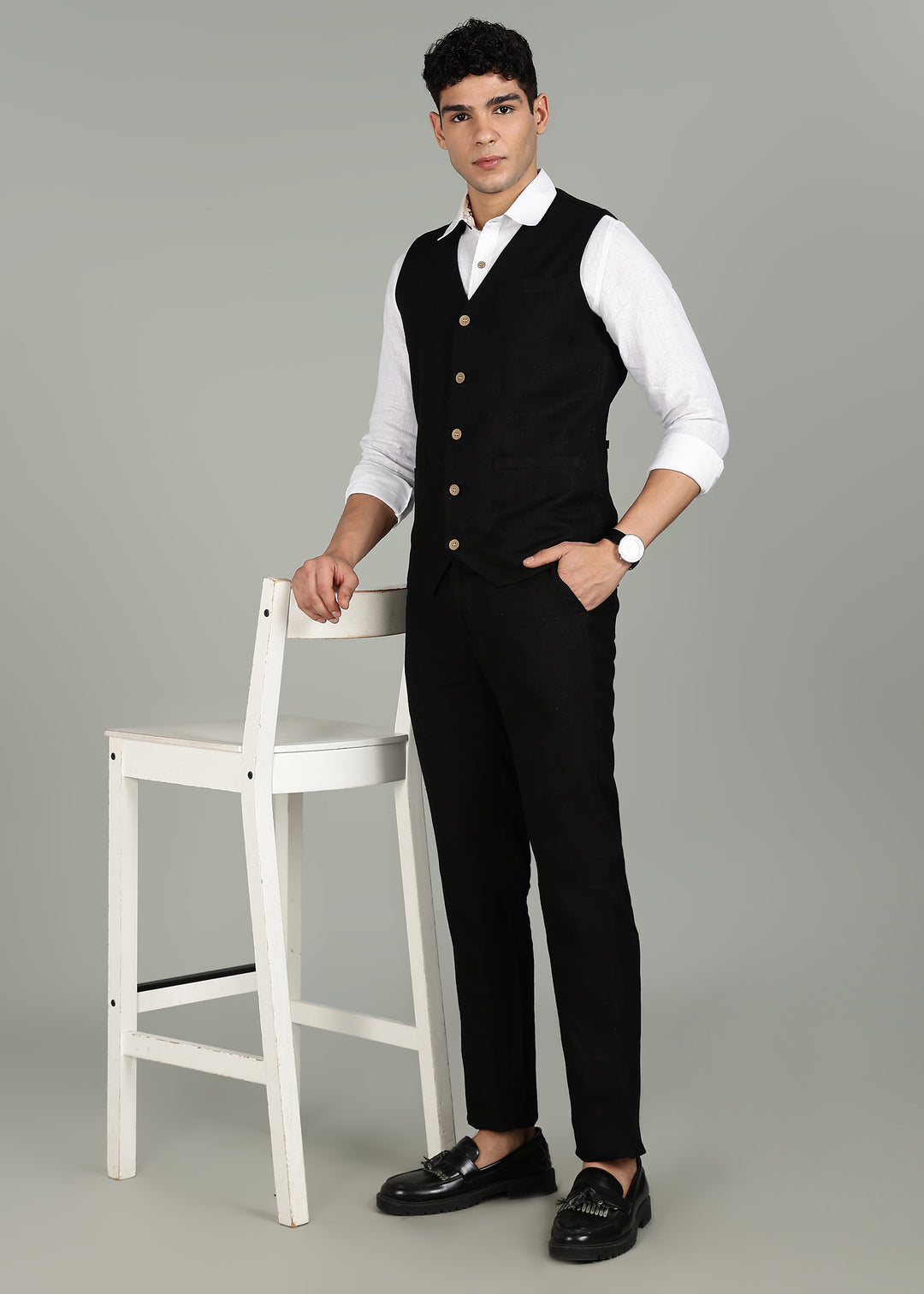 Man wearing a 100% pure linen black waistcoat in 25 LEA over a white shirt against a gray background