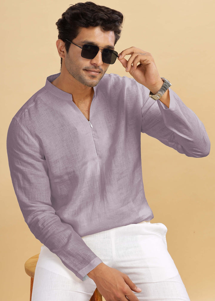 Man wearing a 100% pure linen cameo pink short kurta and white pants against a beige background