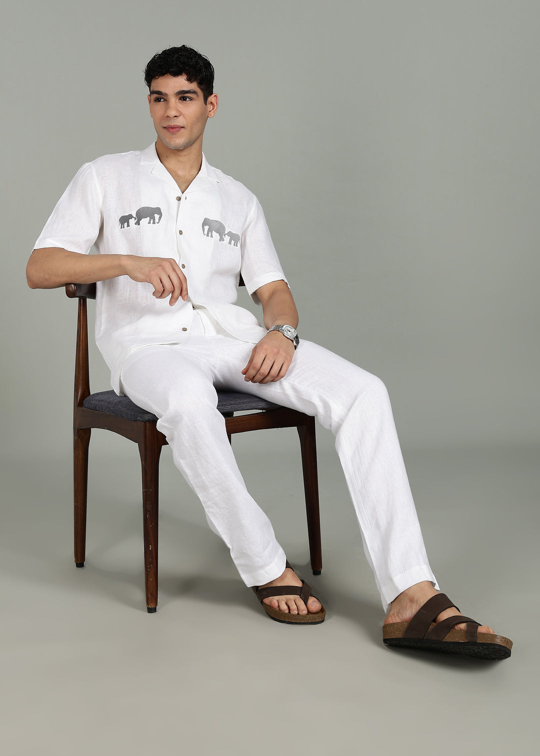 Man wearing a 100% pure linen white shirt in 44 LEA with elephant embroidery on a gray background
