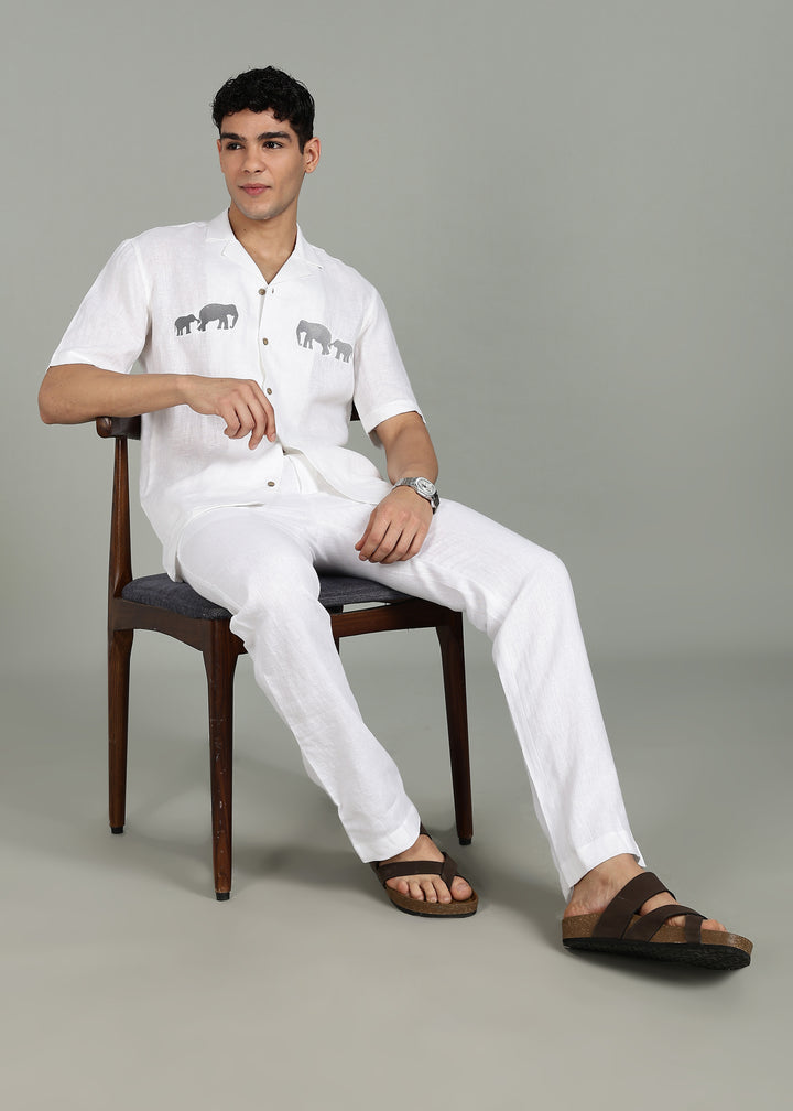 Man wearing a 100% pure linen white shirt in 44 LEA with elephant embroidery on a gray background