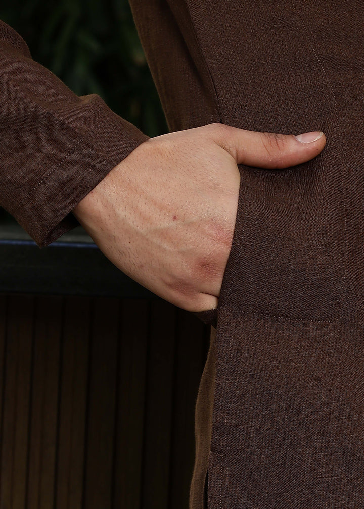Man wearing a 100% pure linen Coffee Brown Kurta, in a green background outdoor.