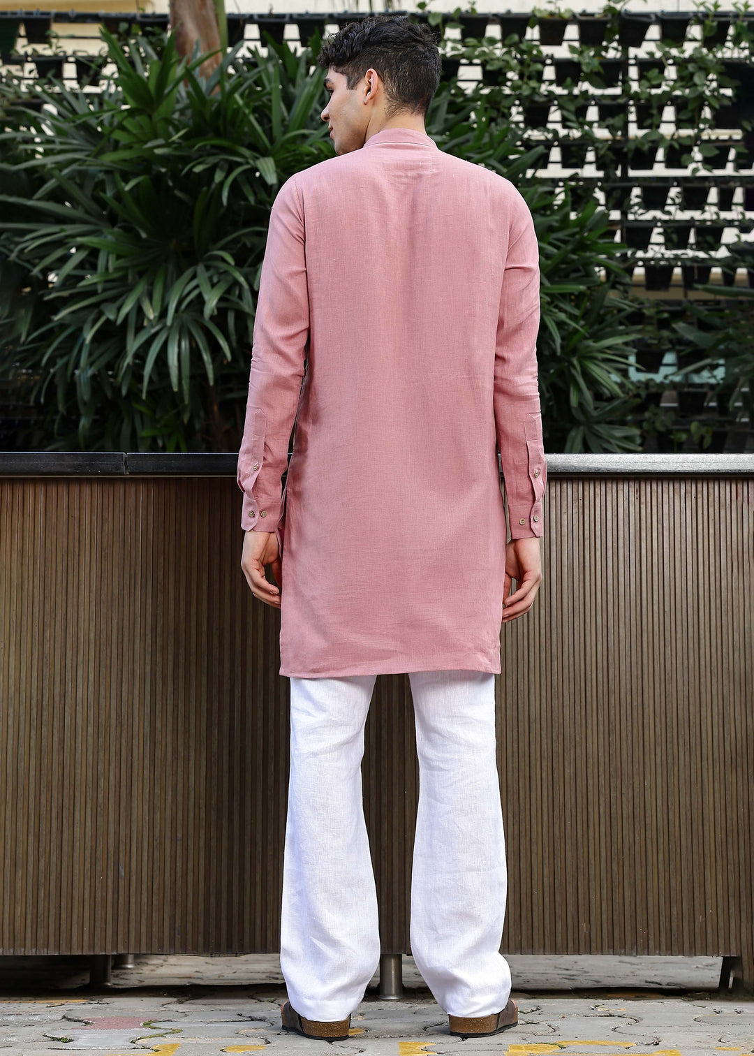 Man wearing a 100% Dusty pink yellow Kurta, in a Green outdoor Background.