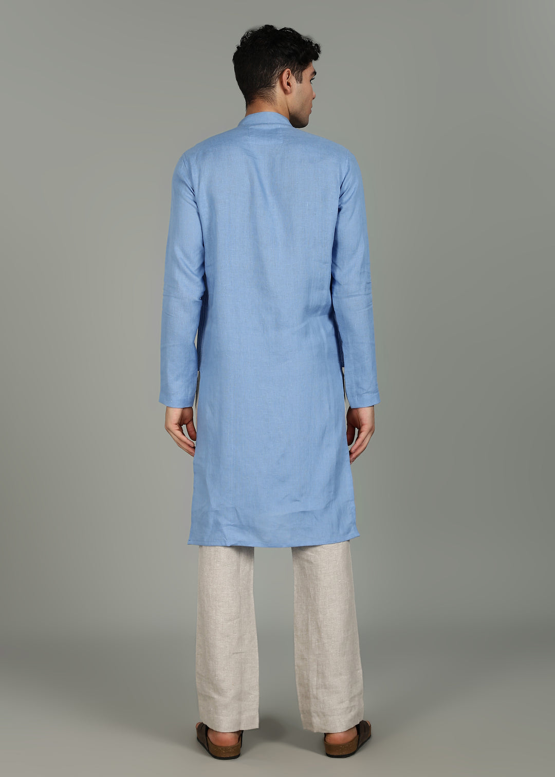 Man wearing a 100% pure linen olympic blue long kurta in 60 LEA with white detailing against a gray background