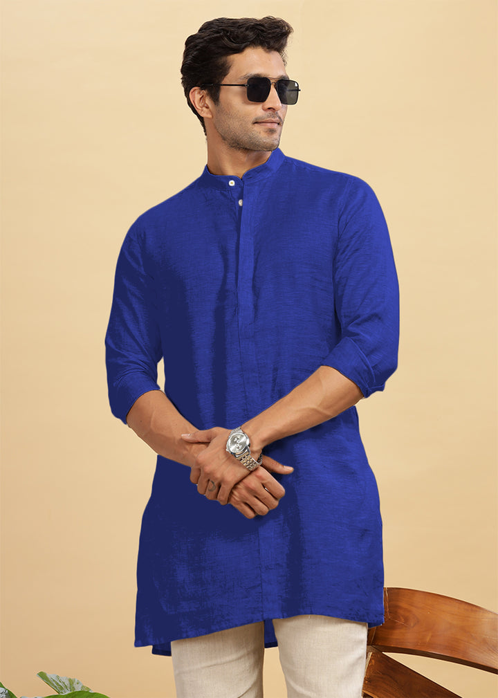 Man wearing a 100% pure linen egyptian blue kurta with sunglasses on a beige background.