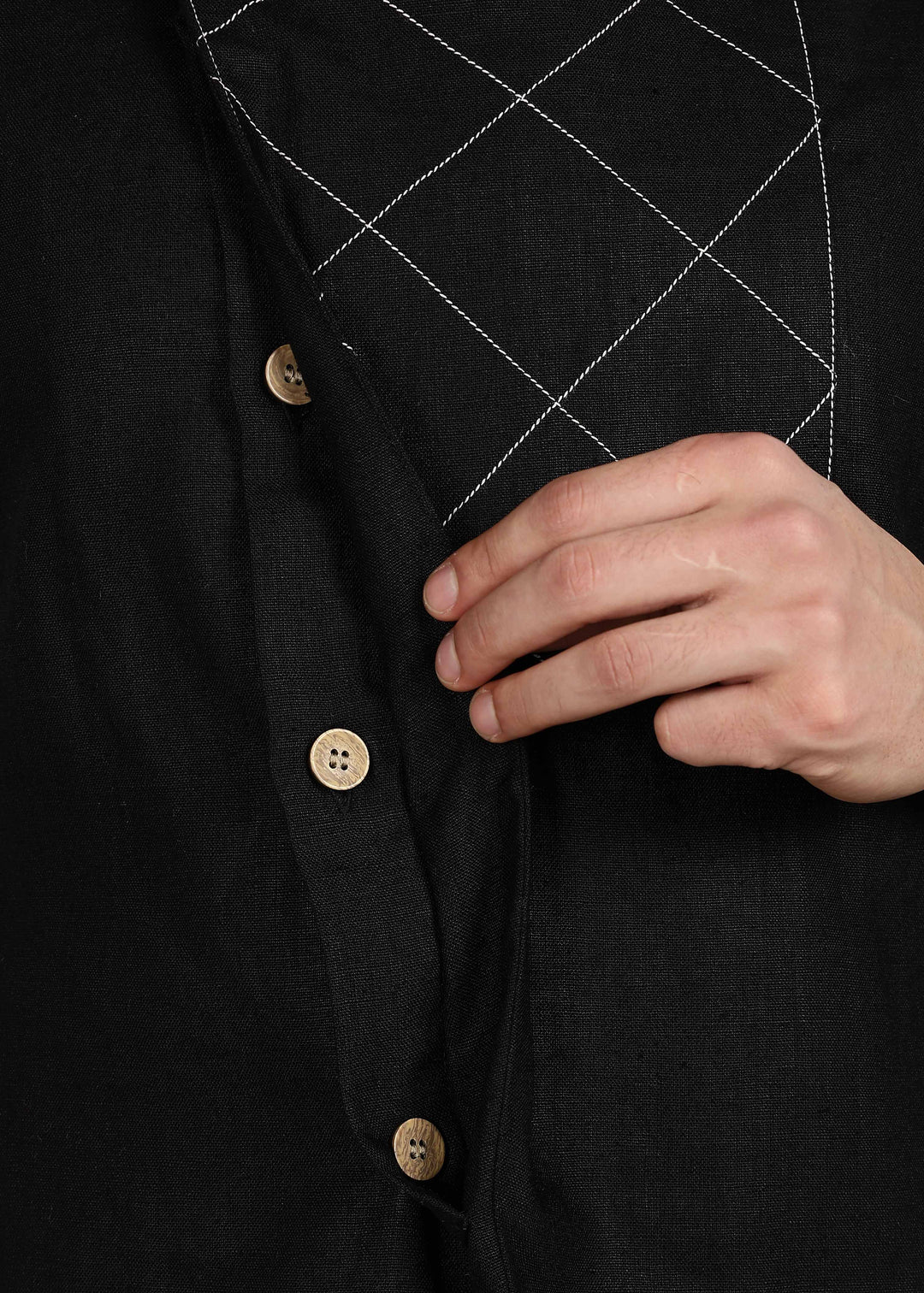 Man wearing a black embroidered 100% pure linen vest in 25 LEA over an ecru shirt on a gray background