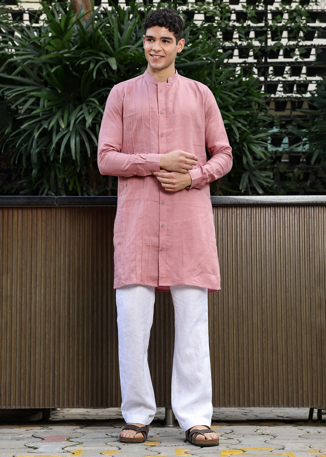 Man wearing a 100% Dusty pink yellow Kurta, in a Green outdoor Background.