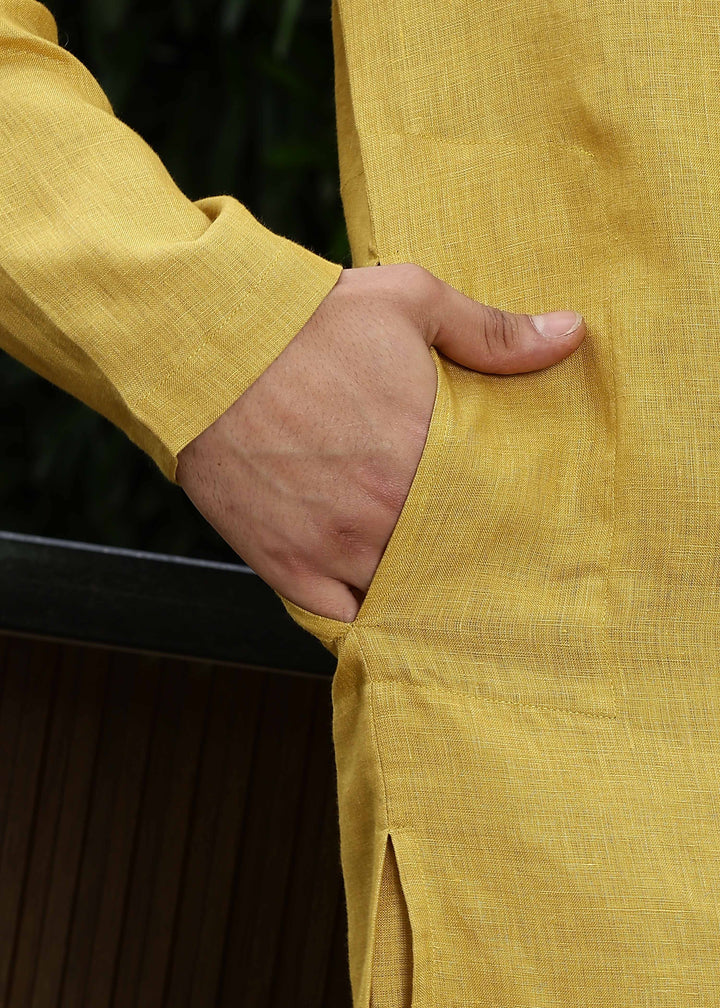 Man wearing a 100% Sunburst yellow 60 lea Kurta, with placket detail, in a Green outdoor Background.