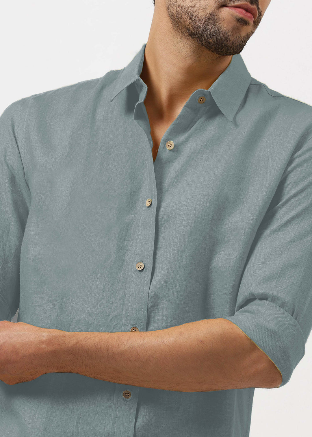 Man wearing a 100% pure linen mineral grey shirt with rolled-up sleeves on a plain background