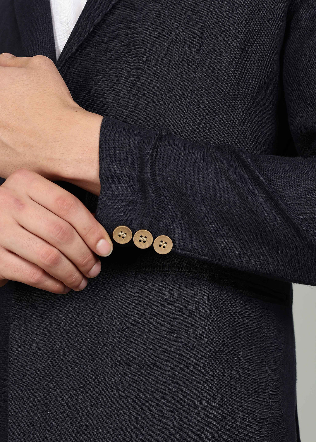 Man wearing a 100% pure linen regal blue jacket in 25 LEA over a white shirt on a gray background
