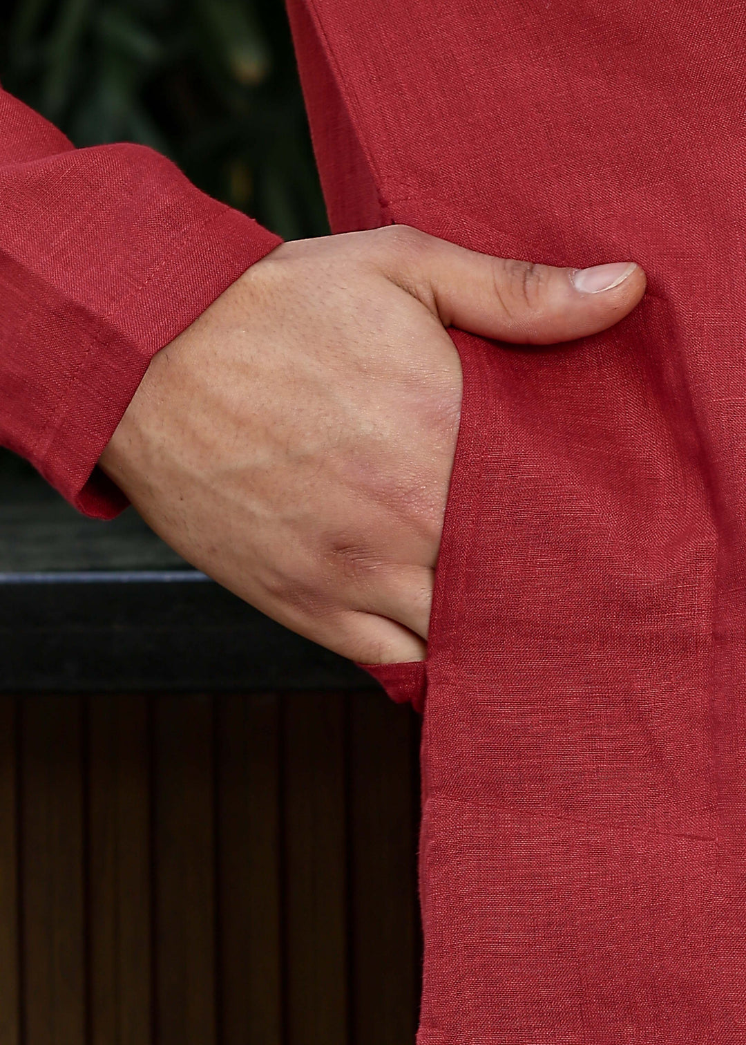 Man wearing mud red Kurta, 100% pure linen, outdoor green background.