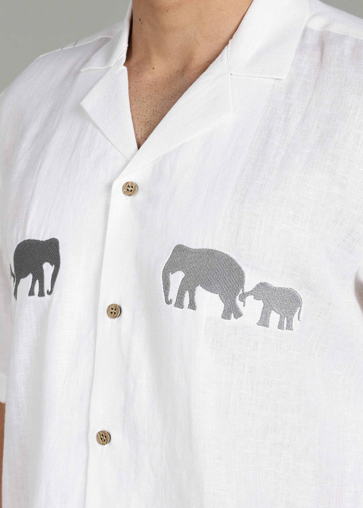Man wearing a 100% pure linen white shirt in 44 LEA with elephant embroidery on a gray background