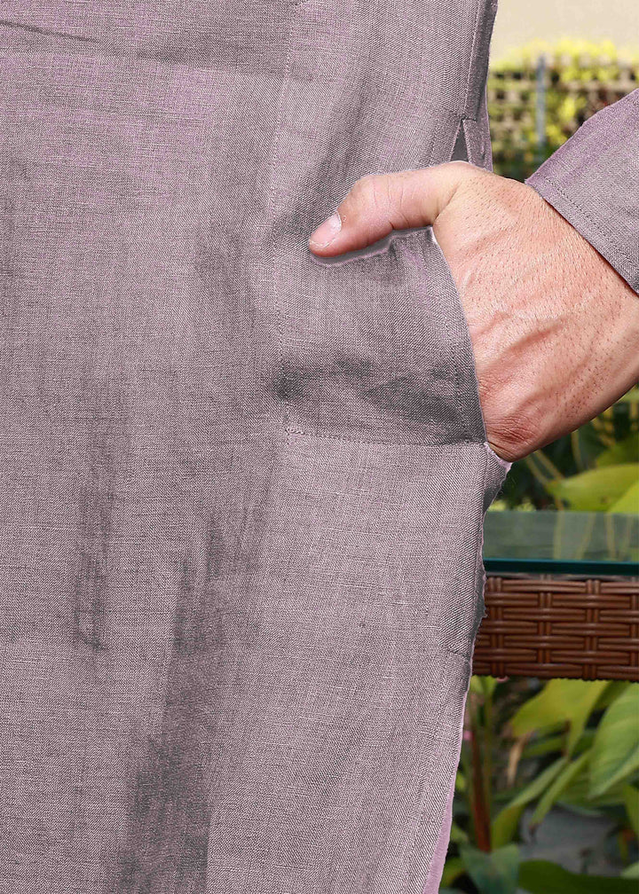 Person wearing a 100% pure linen cameo pink long kurta with a pocket detail, outdoors.