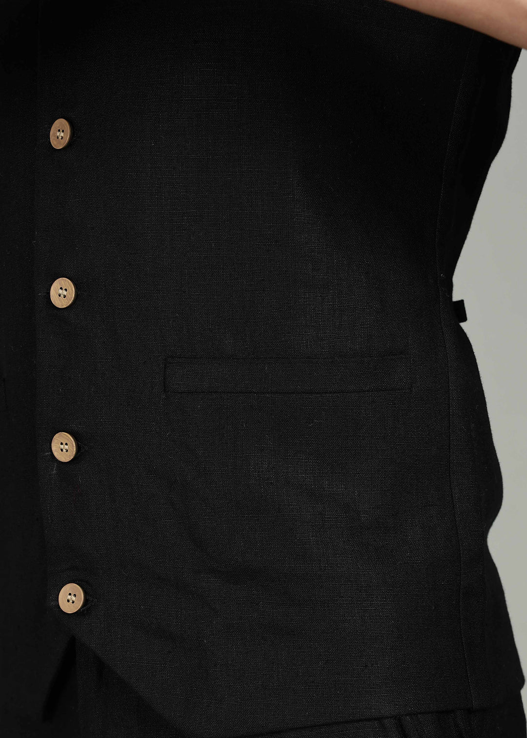 Man wearing a 100% pure linen black waistcoat in 25 LEA over a white shirt against a gray background