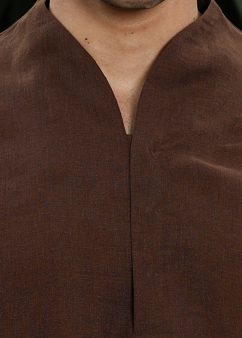 Man wearing a 100% pure linen Coffee Brown Kurta, in a green background outdoor.
