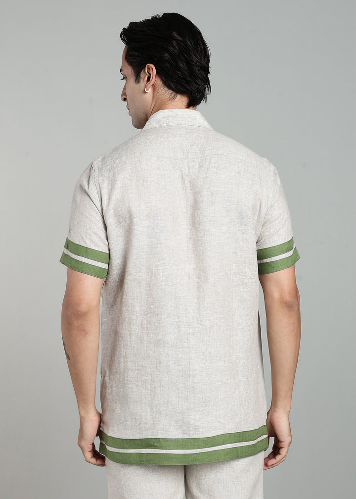 Man wearing 100% pure linen cuban-collar shirt in pure ecru with cossack-green accents in 60 LEA