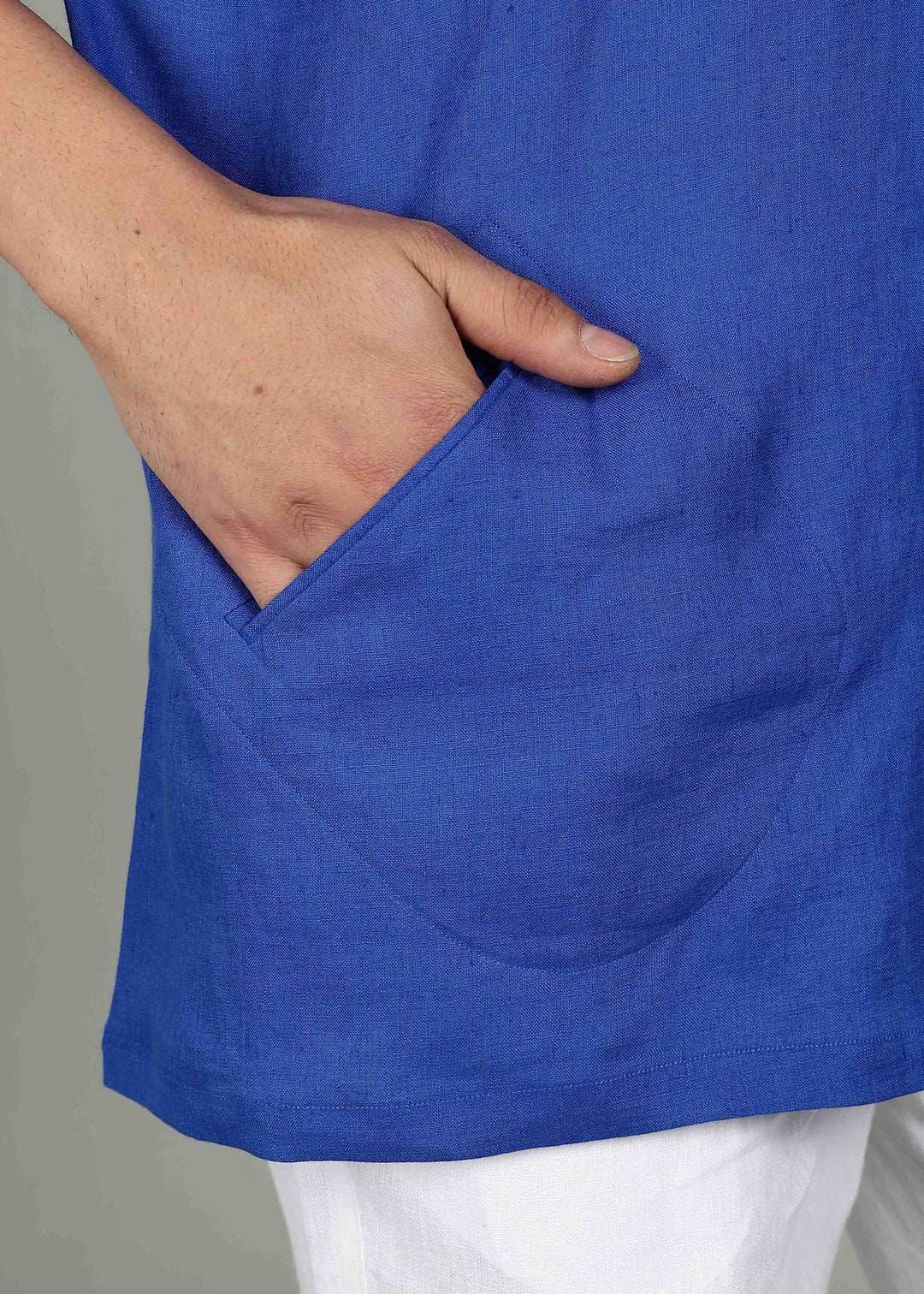 Man wearing a 100% pure linen egyptian blue short kurta in 60 LEA with a gray background