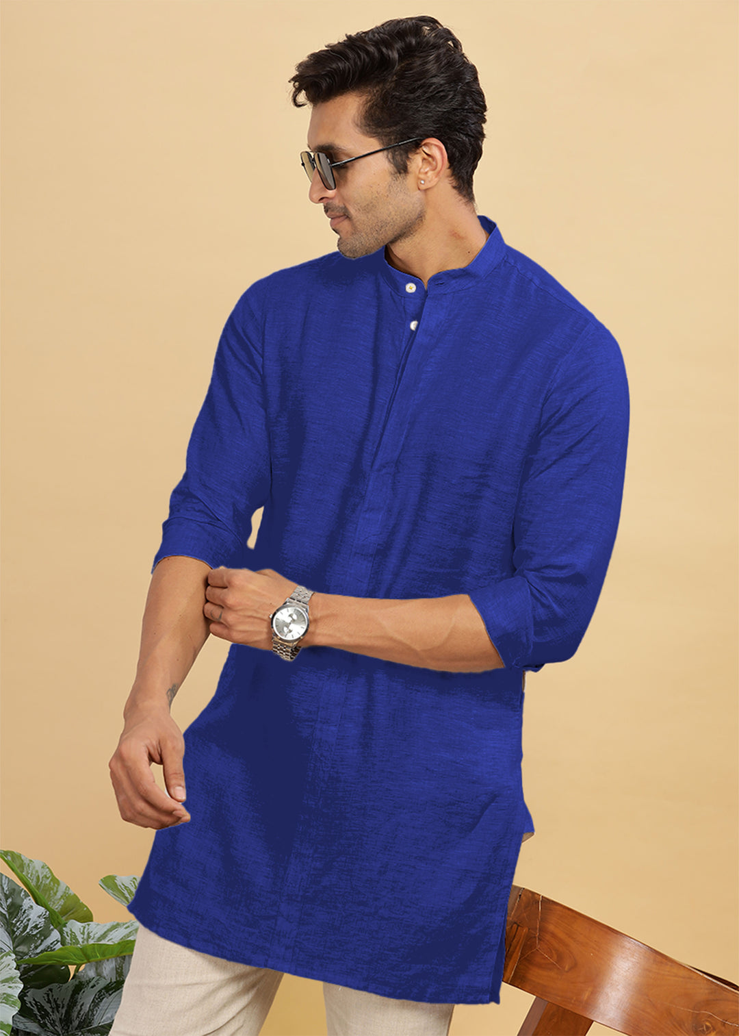 Man wearing a 100% pure linen egyptian blue kurta with sunglasses and a watch on a beige background