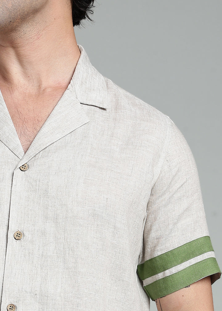 Man wearing 100% pure linen cuban-collar shirt in pure ecru with cossack-green accents in 60 LEA
