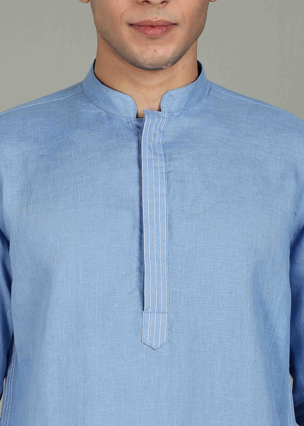 Man wearing a 100% pure linen olympic blue long kurta in 60 LEA with white detailing against a gray background