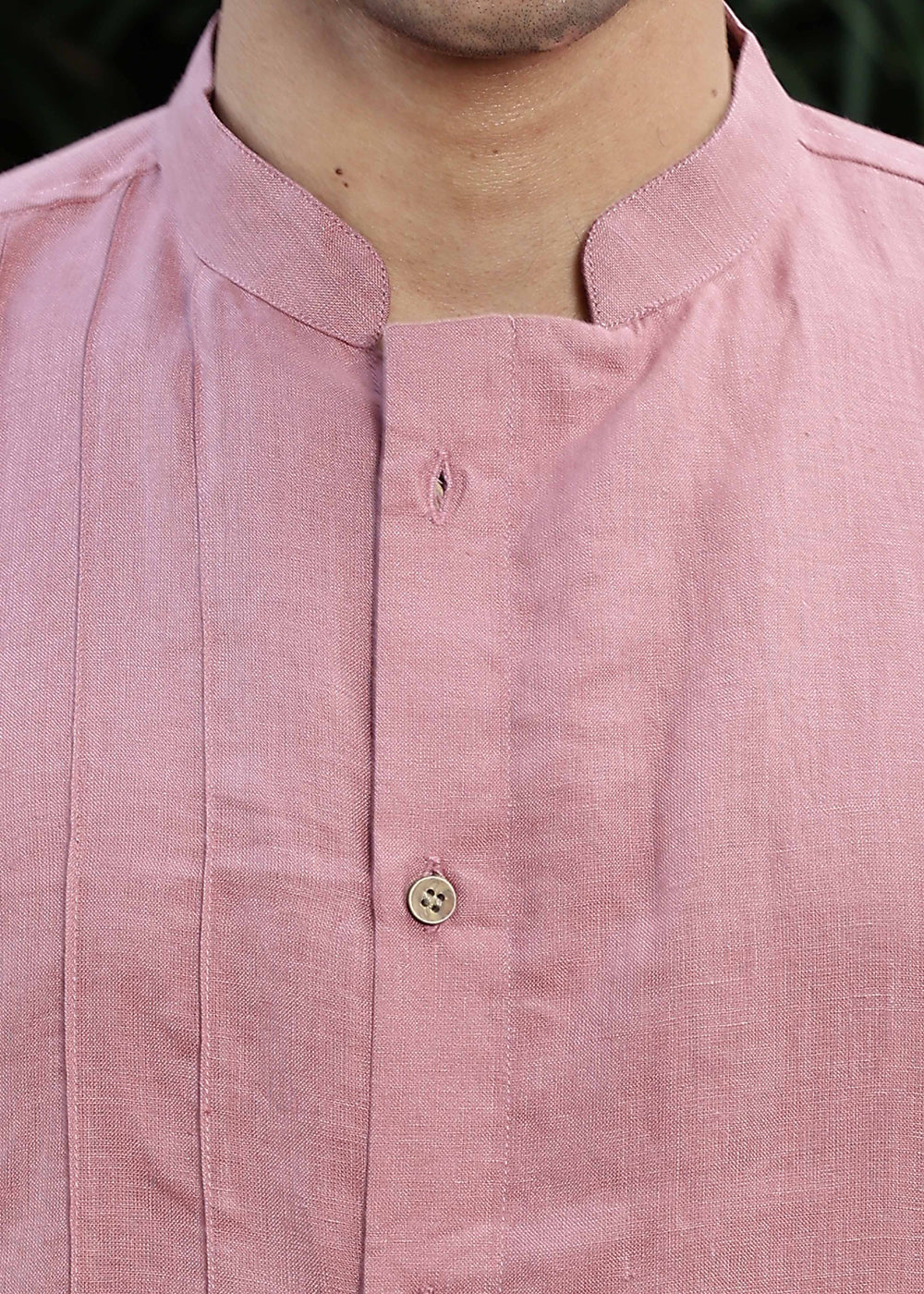 Man wearing a 100% Dusty pink yellow Kurta, in a Green outdoor Background.
