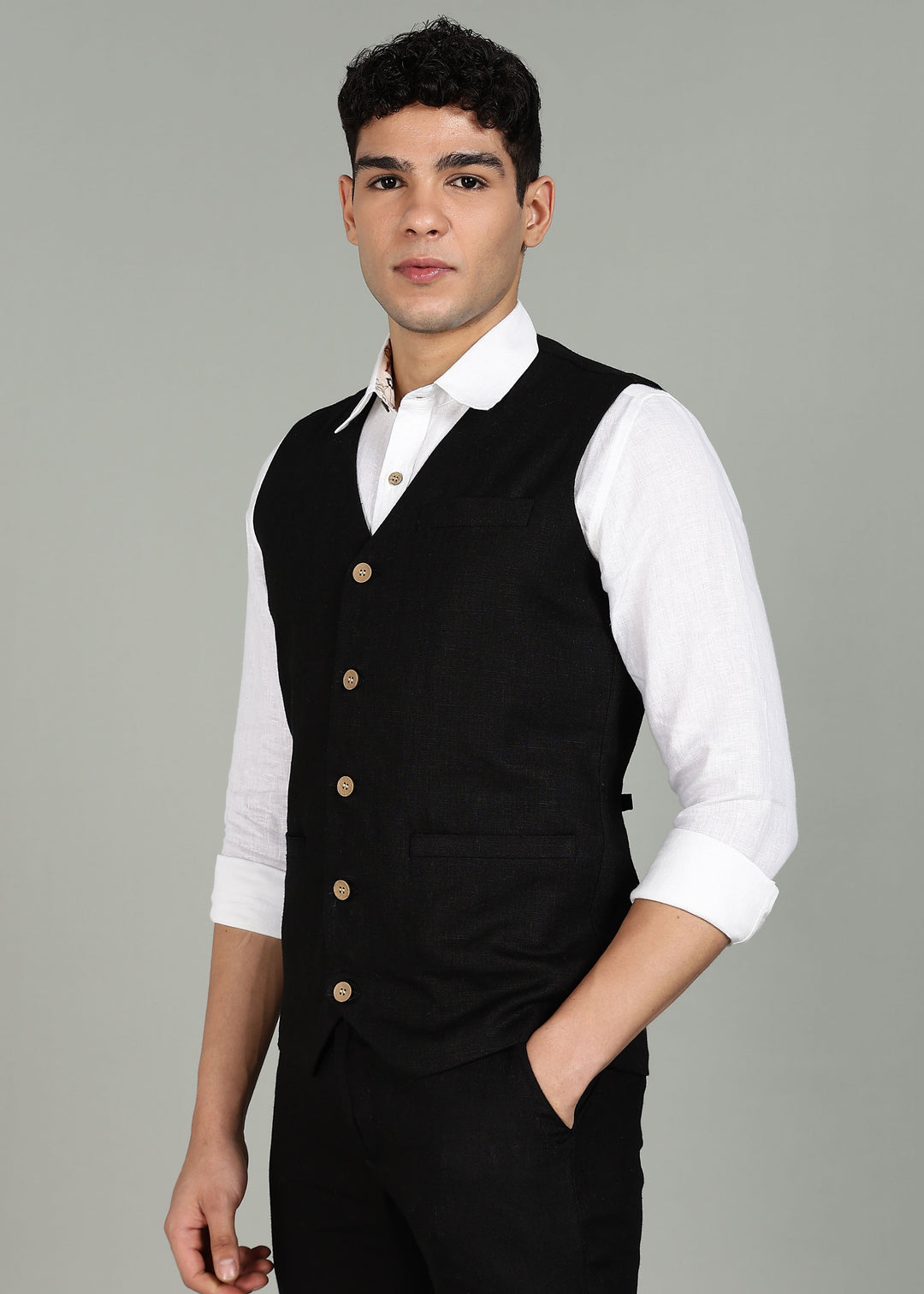Man wearing a 100% pure linen black waistcoat in 25 LEA over a white shirt against a gray background