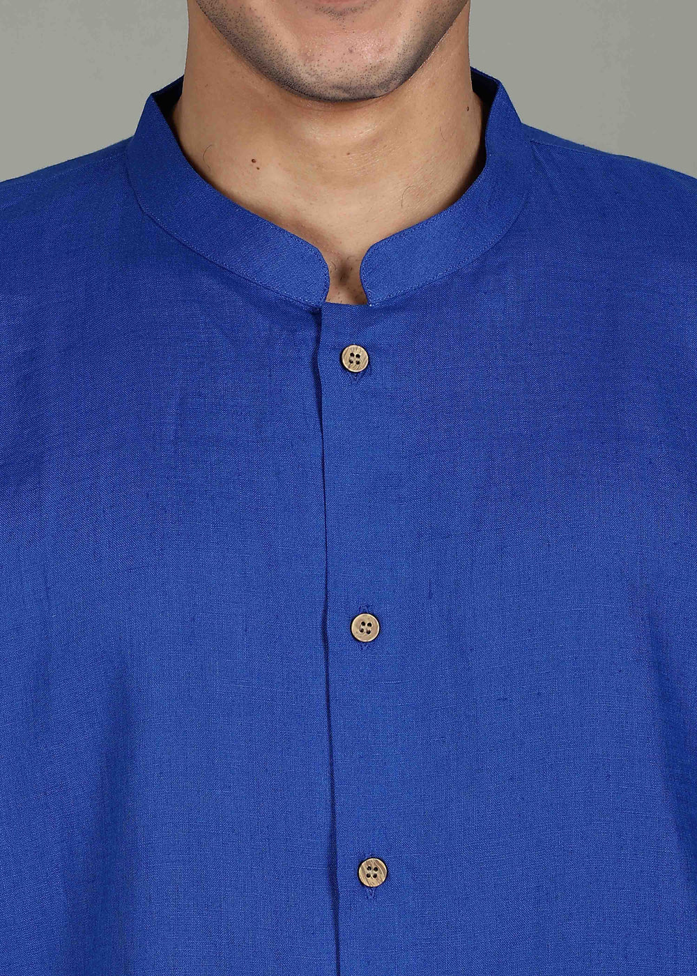Man wearing a 100% pure linen egyptian blue short kurta in 60 LEA with a gray background