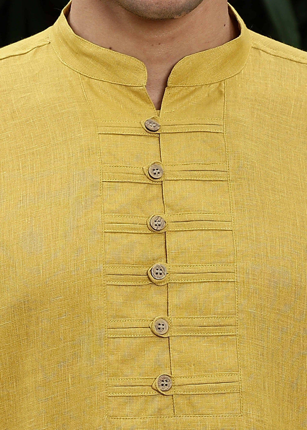 Man wearing a 100% Sunburst yellow 60 lea Kurta, with placket detail, in a Green outdoor Background.