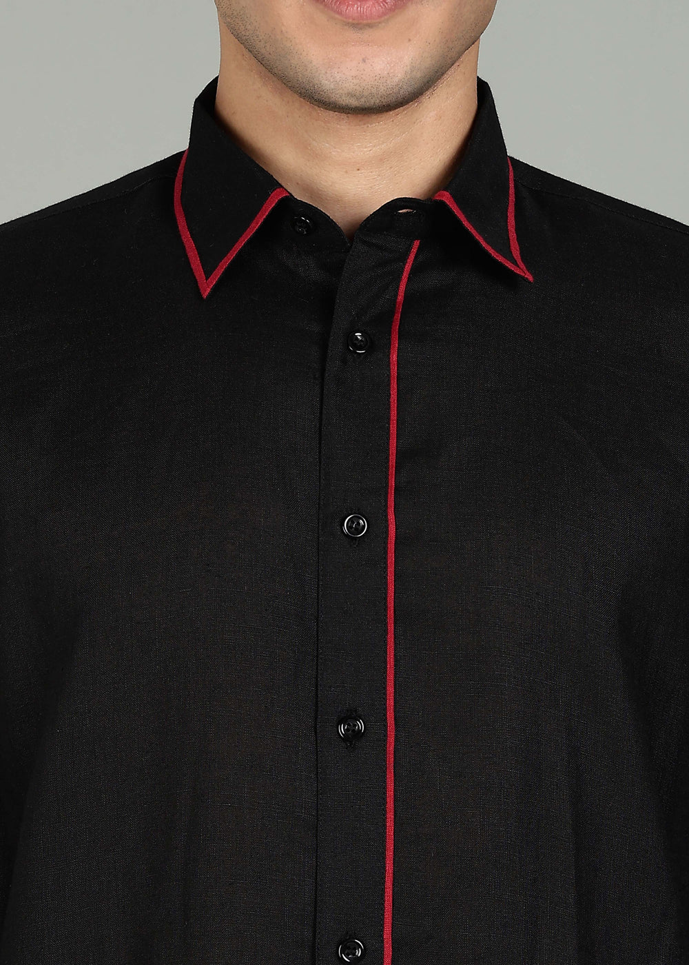 Man wearing a 100% pure linen black long kurta in 60 LEA with red piping detail with a gray background