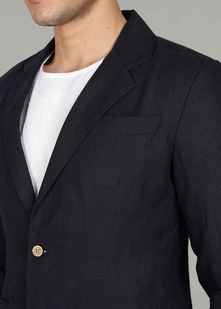 Man wearing a 100% pure linen regal blue jacket in 25 LEA over a white shirt on a gray background