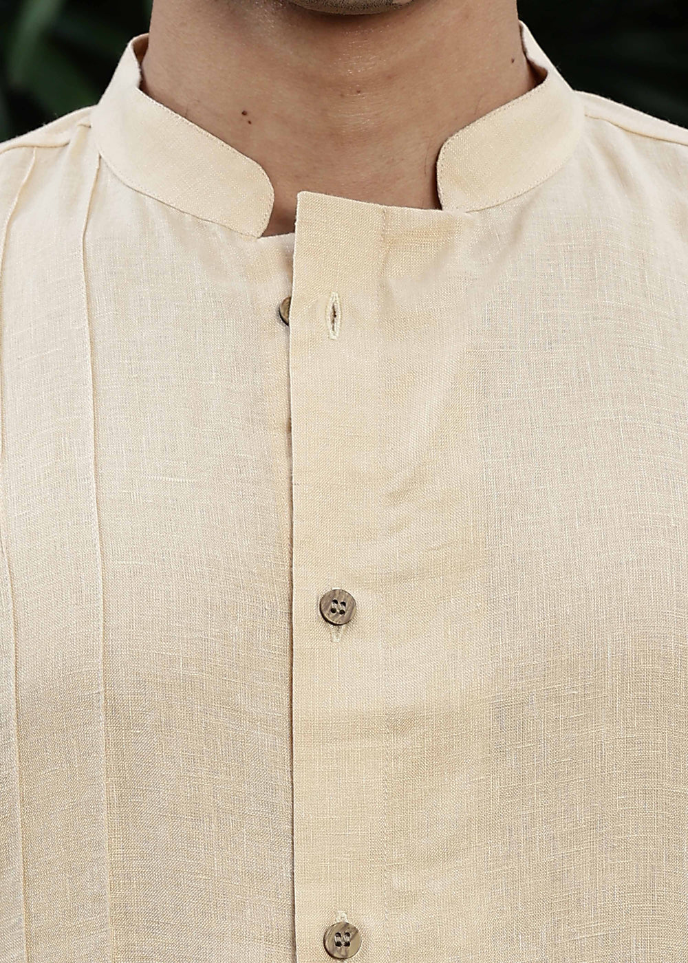 Man wearing a 100% pure light tea yellow Kurta, in a Green outdoor Background.