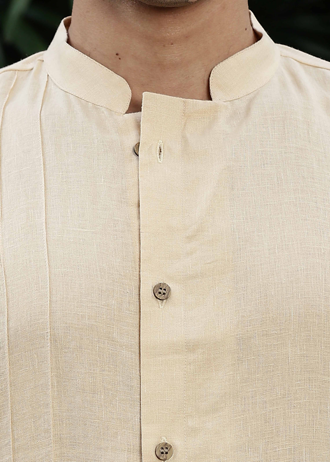 Man wearing a 100% pure light tea yellow Kurta, in a Green outdoor Background.