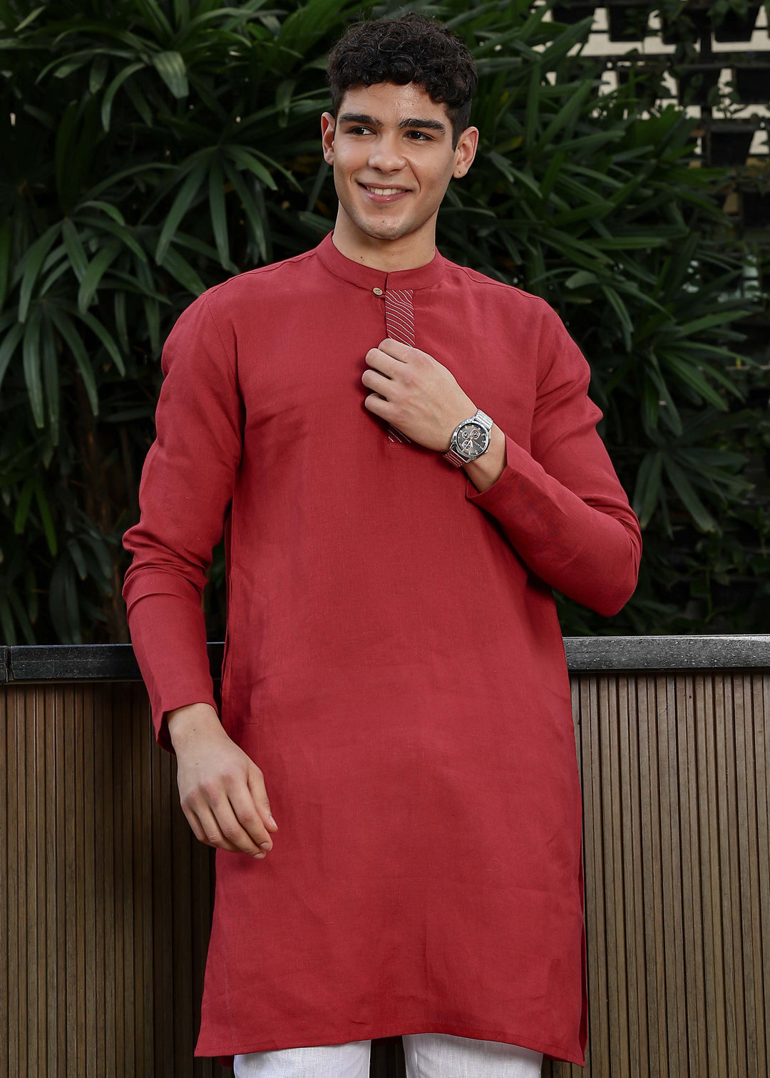 Man wearing mud red Kurta, 100% pure linen, outdoor green background.