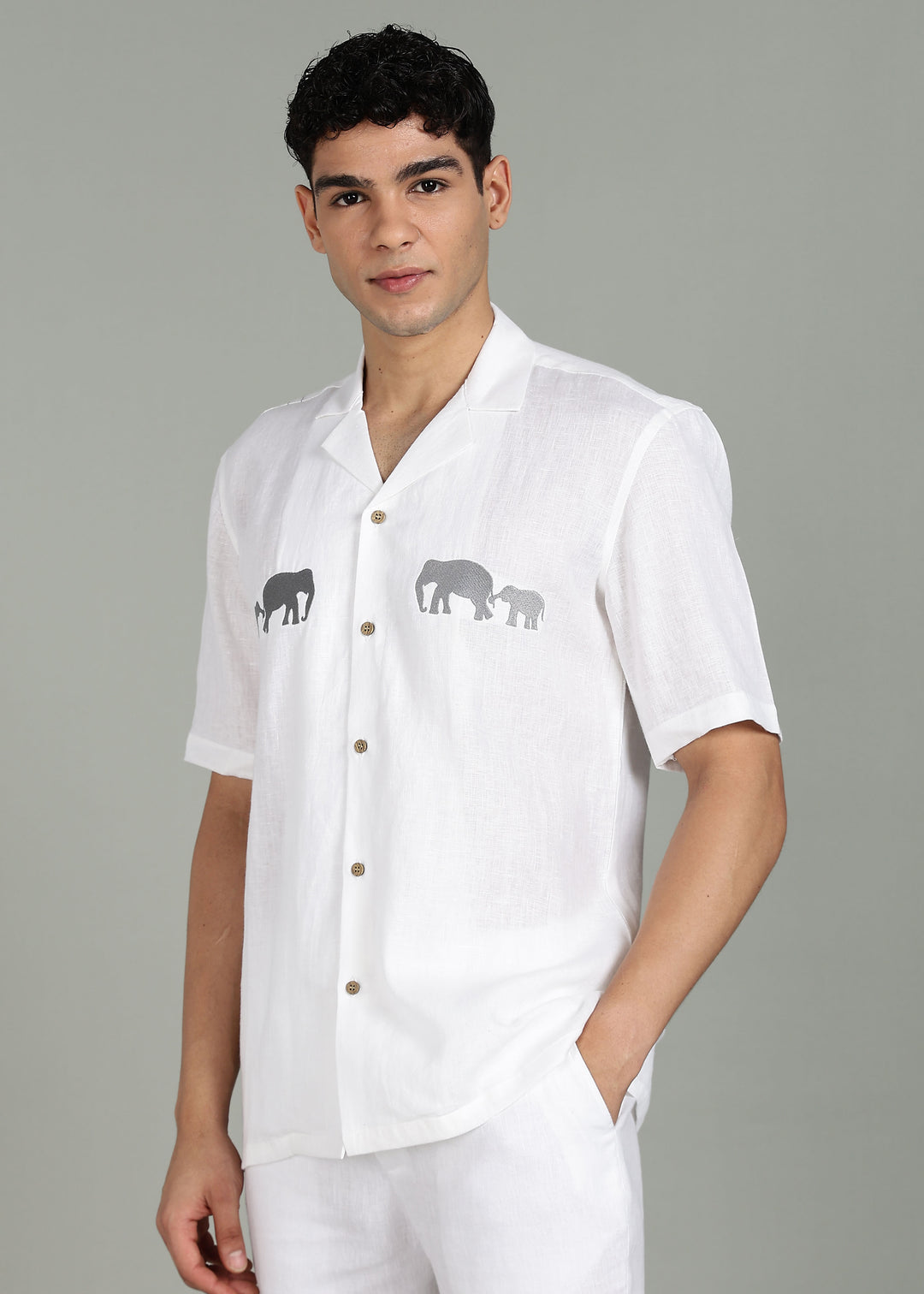 Man wearing a 100% pure linen white shirt in 44 LEA with elephant embroidery on a gray background