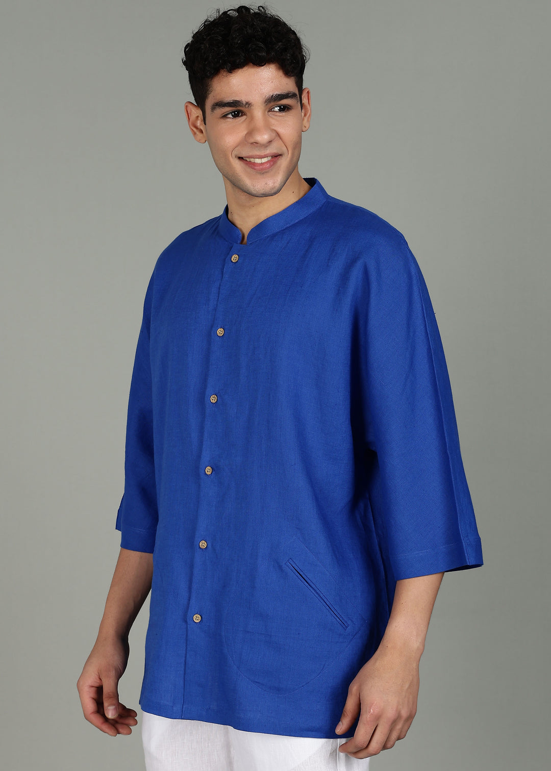 Man wearing a 100% pure linen egyptian blue short kurta in 60 LEA with a gray background