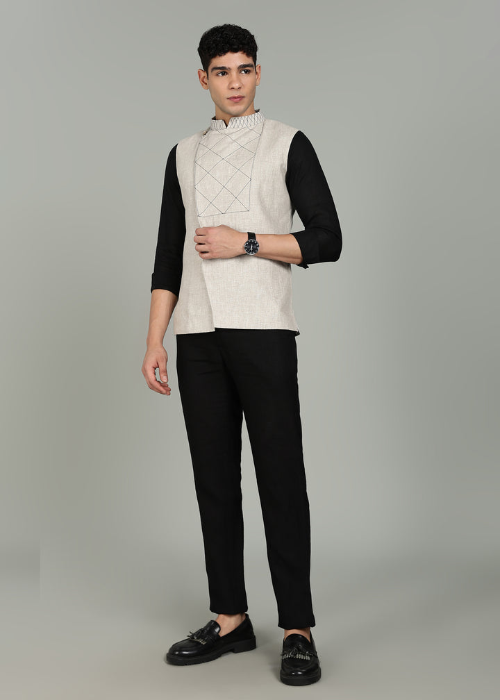 Man wearing an ecru 100% pure linen embroidered vest in 25 LEA over a black shirt on a gray background