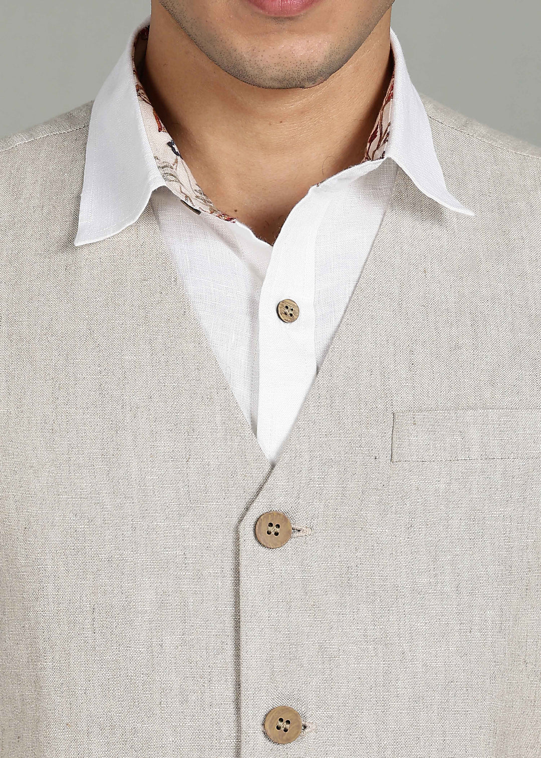 Man wearing a 100% pure linen ecru waistcoat in 25 LEA over a white shirt against a gray background