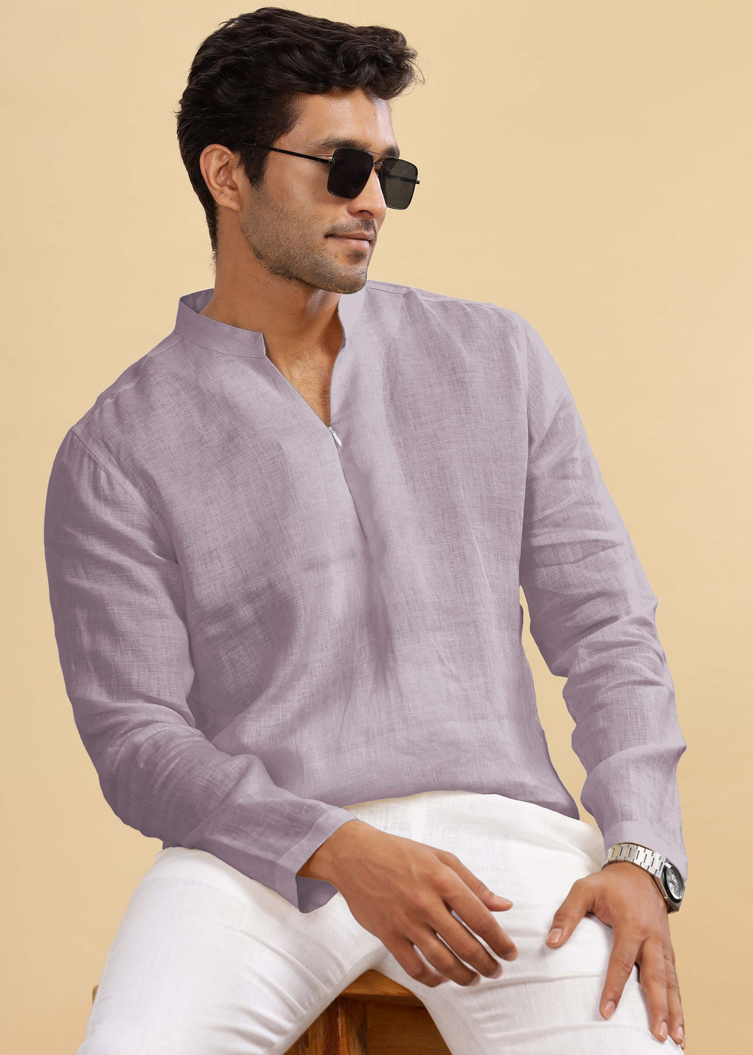 Man wearing a 100% pure linen cameo pink short kurta and white pants against a beige background