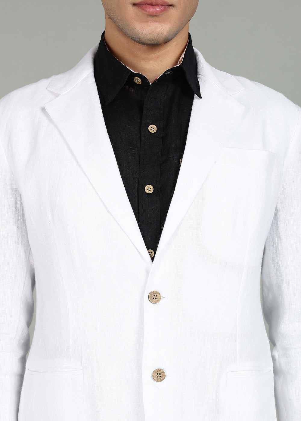 Man wearing a 100% pure linen white Jacket in 25 LEA over a black shirt on a gray background