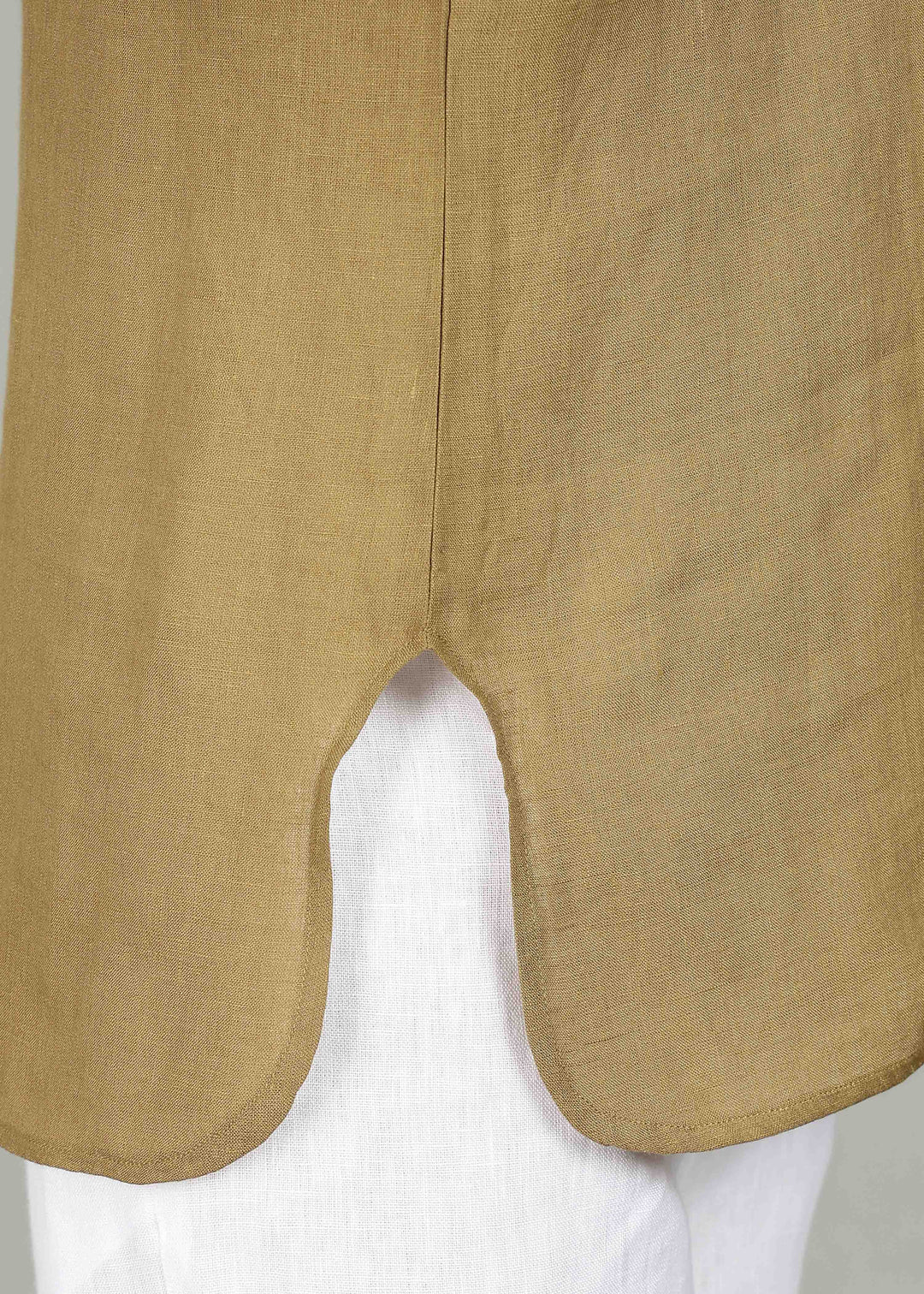 Man wearing a 100% pure linen golden olive green short kurta in 60 LEA with white pants against a gray background